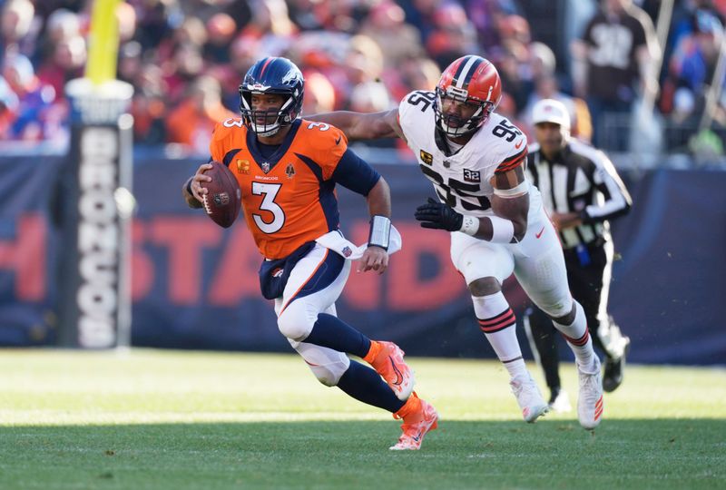 Denver Broncos quarterback Russell Wilson (3) is pursued by Cleveland Browns defensive end Myles Garrett (95) in the first half of an NFL football game Sunday, Nov. 26, 2023, in Denver. (AP Photo/David Zalubowski)