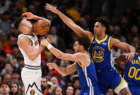 DENVER, CO - DECEMBER 25: Klay Thompson (11) of the Golden State Warriors grabs the arm of Michael Porter Jr. (1) of the Denver Nuggets as Trayce Jackson-Davis (32) of the Golden State Warriors adds help during the first quarter at Ball Arena in Denver on Monday, December 25, 2023. (Photo by AAron Ontiveroz/The Denver Post)