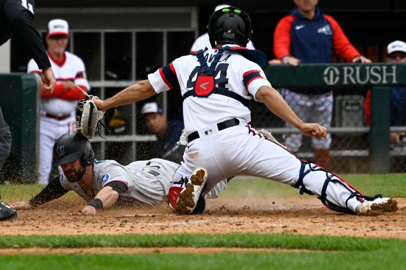 Jun 11, 2023; Chicago, Illinois, USA;  Miami Marlins shortstop Jon Berti (5) slides safely into home plate under Chicago White Sox catcher Seby Zavala (44) during the ninth inning at Guaranteed Rate Field. Mandatory Credit: Matt Marton-USA TODAY Sports