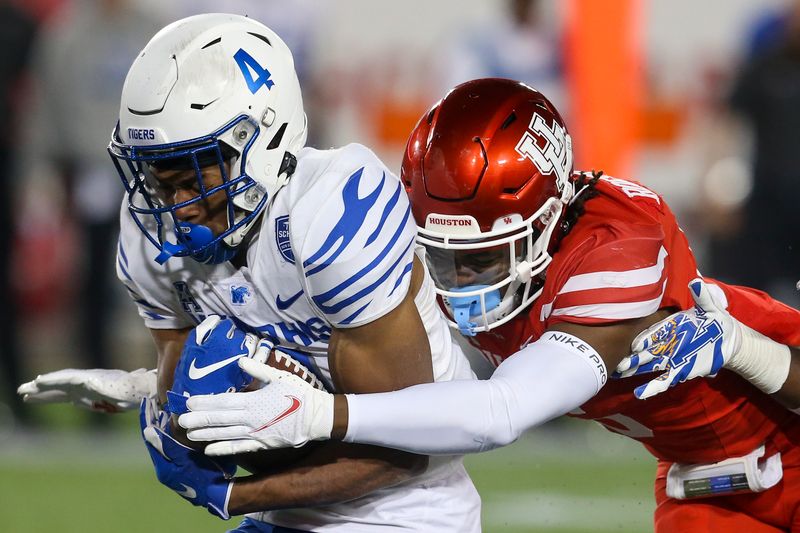 Nov 19, 2021; Houston, Texas, USA; Memphis Tigers wide receiver Calvin Austin III (4) breaks the tackle of  Houston Cougars cornerback Jayce Rogers (16) in the third quarter at TDECU Stadium. Houston Cougars won 31 to 13. Mandatory Credit: Thomas Shea-USA TODAY Sports