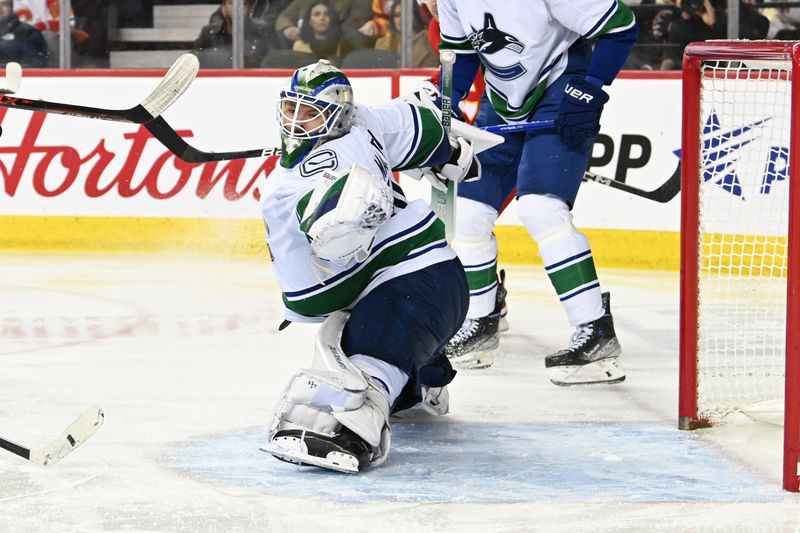 Dec 31, 2022; Calgary, Alberta, CAN; Vancouver Canucks goalie Spencer Martin (30) stops a shot against the Calgary Flames in the third period at Scotiabank Saddledome. Mandatory Credit: Candice Ward-USA TODAY Sports