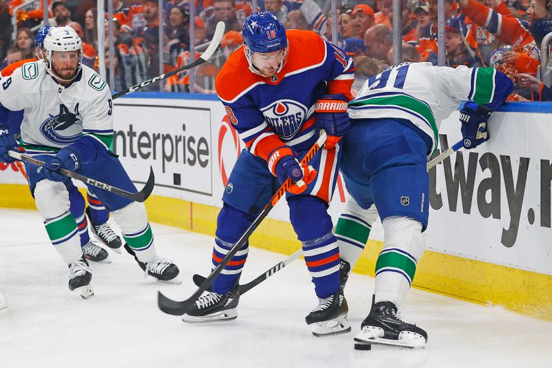 May 12, 2024; Edmonton, Alberta, CAN; Edmonton Oilers forward Zach Hyman (18) and Vancouver Canucks defensemen Nikita Zadorov (91) Battle along the boards for a loose puck during the first period in game three of the second round of the 2024 Stanley Cup Playoffs at Rogers Place. Mandatory Credit: Perry Nelson-USA TODAY Sports