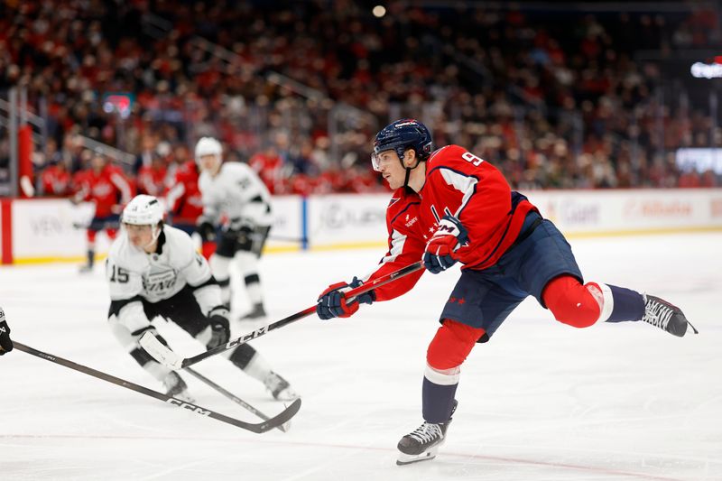 Nov 17, 2025; Washington, District of Columbia, USA; Washington Capitals right wing Ryan Leonard (9) shoots the puck as Los Angeles Kings center Alex Turcotte (15) defends during the third period at Capital One Arena. Mandatory Credit: Geoff Burke-Imagn Images