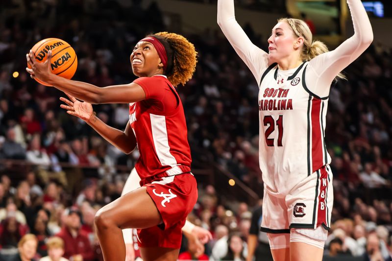 Feb 22, 2024; Columbia, South Carolina, USA; Alabama Crimson Tide guard Loyal McQueen (0) drives past South Carolina Gamecocks forward Chloe Kitts (21) in the second half at Colonial Life Arena. Mandatory Credit: Jeff Blake-USA TODAY Sports