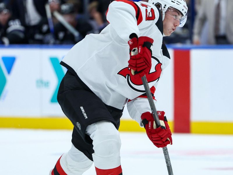 Nov 16, 2024; Tampa, Florida, USA; New Jersey Devils defenseman Luke Hughes (43) shoots the puck against the Tampa Bay Lightning in the second period at Amalie Arena. Mandatory Credit: Nathan Ray Seebeck-Imagn Images