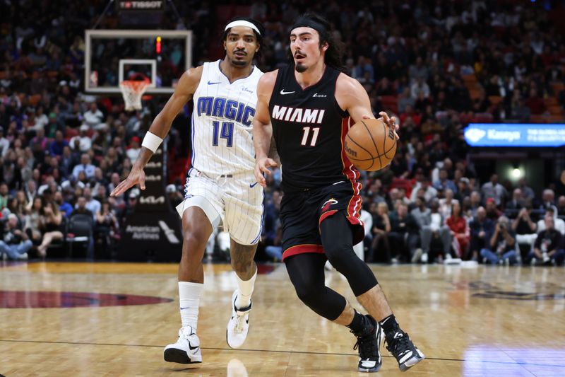 MIAMI, FLORIDA - FEBRUARY 06: Jaime Jaquez Jr. #11 of the Miami Heat drives against Gary Harris #14 of the Orlando Magic during the fourth quarter of the game at Kaseya Center on February 06, 2024 in Miami, Florida. NOTE TO USER: User expressly acknowledges and agrees that, by downloading and or using this photograph, User is consenting to the terms and conditions of the Getty Images License Agreement. (Photo by Megan Briggs/Getty Images)