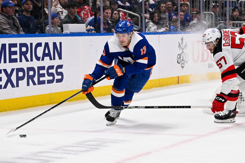 Mar 24, 2024; Elmont, New York, USA;  New York Islanders center Mathew Barzal (13) skates with the puck defended by New Jersey Devils defenseman Nick DeSimone (57) during the second period at UBS Arena. Mandatory Credit: Dennis Schneidler-USA TODAY Sports