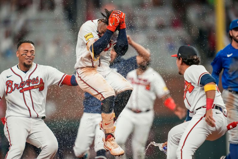 Sep 27, 2023; Cumberland, Georgia, USA; Atlanta Braves second baseman Ozzie Albies (1) gets splashed with water by teammates after getting the game winning hit against the Chicago Cubs during the tenth inning at Truist Park. Mandatory Credit: Dale Zanine-USA TODAY Sports