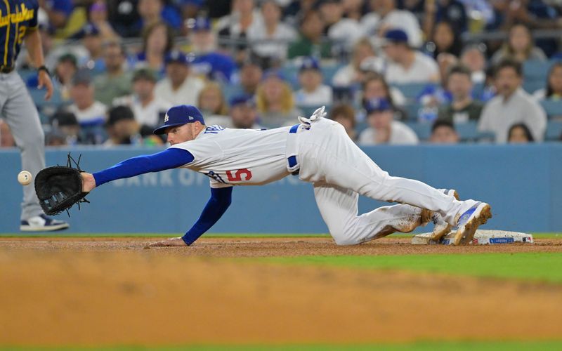 Aug 16, 2023; Los Angeles, California, USA;  Milwaukee Brewers center fielder Joey Wiemer (28) is out at first as Los Angeles Dodgers first baseman Freddie Freeman (5) reaches for a wide throw by third baseman Max Muncy (13) in the fifth inning at Dodger Stadium. Mandatory Credit: Jayne Kamin-Oncea-USA TODAY Sports