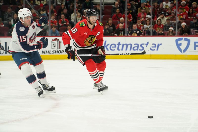 Dec 1, 2024; Chicago, Illinois, USA; Columbus Blue Jackets defenseman Dante Fabbro (15) and Chicago Blackhawks center Jason Dickinson (16) go for the puck during the first period at United Center. Mandatory Credit: David Banks-Imagn Images