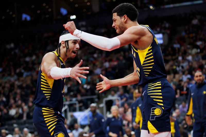 TORONTO, CANADA - APRIL 9: Tyrese Haliburton #0 and Andrew Nembhard #2 of the Indiana Pacers react against the Toronto Raptors during second half of their NBA game at Scotiabank Arena on April 9, 2024 in Toronto, Canada. NOTE TO USER: User expressly acknowledges and agrees that, by downloading and or using this photograph, User is consenting to the terms and conditions of the Getty Images License Agreement. (Photo by Cole Burston/Getty Images)