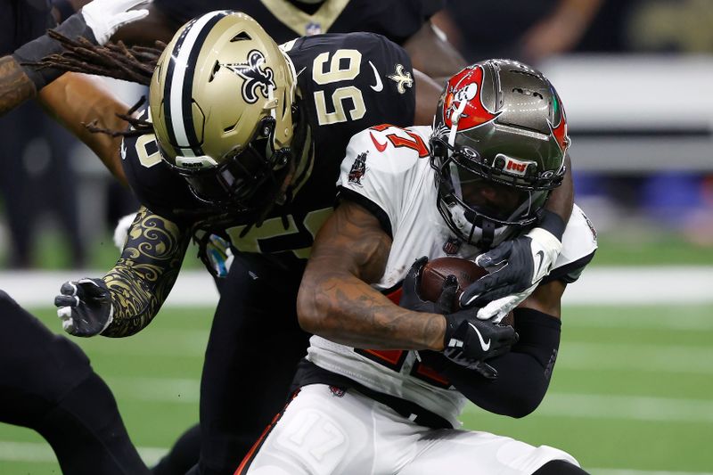 Tampa Bay Buccaneers wide receiver Sterling Shepard, right, runs against New Orleans Saints linebacker Demario Davis (56) during the first half of an NFL football game in New Orleans, Sunday, Oct. 13, 2024. (AP Photo/Butch Dill)