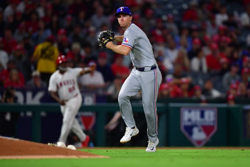 Sep 27, 2024; Anaheim, California, USA; Texas Rangers third baseman Matt Duffy (9) throws to first for the out against Los Angeles Angels second baseman Michael Stefanic (38) during the seventh inning at Angel Stadium. Mandatory Credit: Gary A. Vasquez-Imagn Images