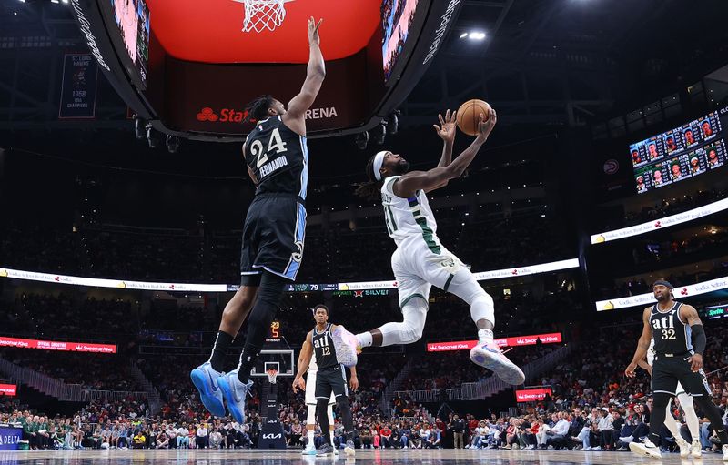 ATLANTA, GEORGIA - MARCH 30:  Patrick Beverley #21 of the Milwaukee Bucks attempts a layup against Bruno Fernando #24 of the Atlanta Hawks during the third quarter at State Farm Arena on March 30, 2024 in Atlanta, Georgia.  NOTE TO USER: User expressly acknowledges and agrees that, by downloading and/or using this photograph, user is consenting to the terms and conditions of the Getty Images License Agreement.  (Photo by Kevin C. Cox/Getty Images)