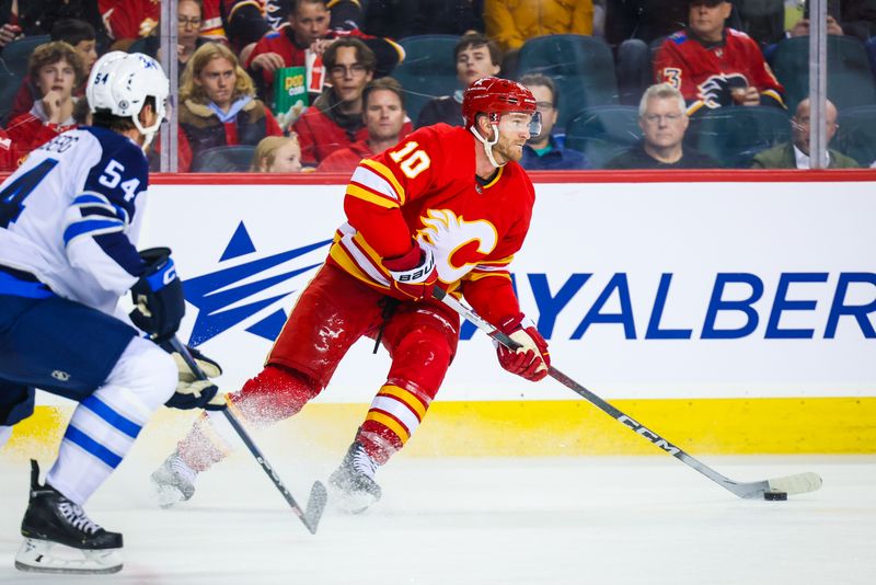 Oct 11, 2023; Calgary, Alberta, CAN; Calgary Flames center Jonathan Huberdeau (10) controls the puck against the Winnipeg Jets during the second period at Scotiabank Saddledome. Mandatory Credit: Sergei Belski-USA TODAY Sports