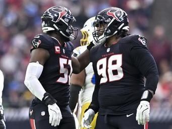 Houston Texans defensive tackle Tim Settle Jr. (98) congratulates defensive end Will Anderson Jr. (51) on his tackle for a loss against the Los Angeles Chargers during the first half of an NFL wild-card playoff football game, Saturday, Jan. 11, 2025, in Houston The Texans defeated the Chargers 32-12. (AP Photo/Maria Lysaker)