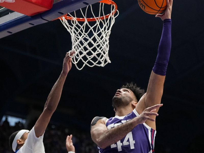 Jan 6, 2024; Lawrence, Kansas, USA; TCU Horned Frogs forward Essam Mostafa (44) shoots against Kansas Jayhawks guard Dajuan Harris Jr. (3) during the first half at Allen Fieldhouse. Mandatory Credit: Jay Biggerstaff-USA TODAY Sports