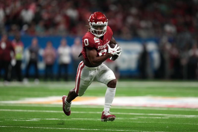 Dec 29, 2021; San Antonio, Texas, USA; Oklahoma Sooners quarterback Caleb Williams (13) carries the ball against the Oregon Ducks in the first half of the 2021 Alamo Bowl at Alamodome. Mandatory Credit: Kirby Lee-USA TODAY Sports