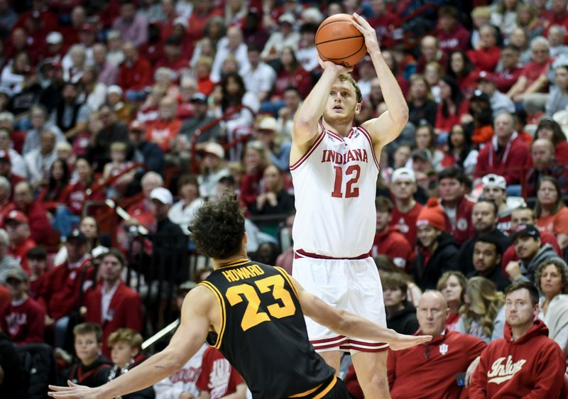 Jan 17, 2026; Bloomington, Indiana, USA; Indiana Hoosiers forward Tucker DeVries (12) shoots the ball over Iowa Hawkeyes guard Isaia Howard (23) during the first half at Simon Skjodt Assembly Hall. Mandatory Credit: Robert Goddin-Imagn Images