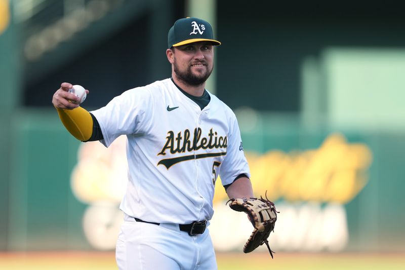 May 3, 2024; Oakland, California, USA; Oakland Athletics first baseman J.D. Davis (5) warms up before the game against the Miami Marlins at Oakland-Alameda County Coliseum. Mandatory Credit: Darren Yamashita-USA TODAY Sports