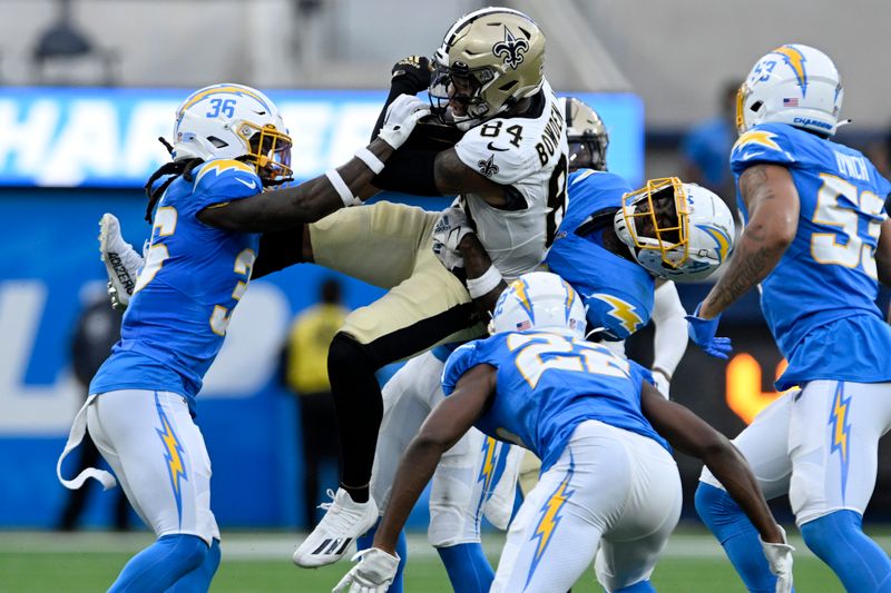 New Orleans Saints wide receiver Lynn Bowden (84) is tackled by Los Angeles Chargers cornerback Ja'Sir Taylor (36) and safety Raheem Layne in the first half of an NFL football game in Inglewood, Calif., Sunday, Aug. 20, 2023. (AP Photo/Alex Gallardo)