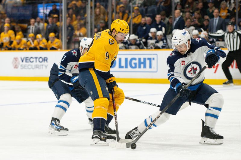 Nov 23, 2024; Nashville, Tennessee, USA;  Winnipeg Jets defenseman Neal Pionk (4) steals the puck from Nashville Predators left wing Filip Forsberg (9) during the first period at Bridgestone Arena. Mandatory Credit: Steve Roberts-Imagn Images