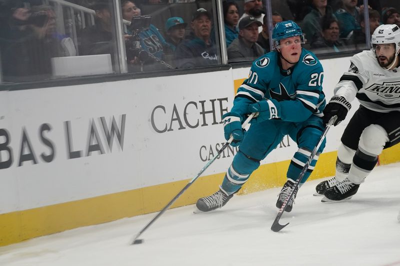 Nov 25, 2024; San Jose, California, USA; San Jose Sharks left wing Fabian Zetterlund (20) advances the puck against Los Angeles Kings center Phillip Danault (24) before scoring a goal in the second period at SAP Center at San Jose. Mandatory Credit: David Gonzales-Imagn Images