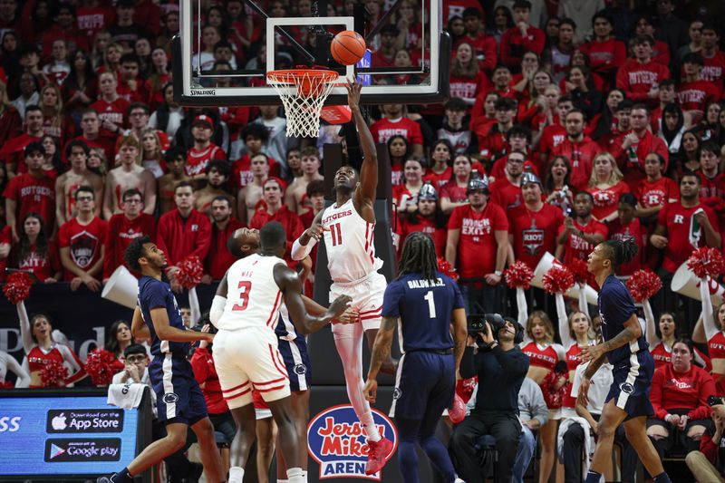 Jan 31, 2024; Piscataway, New Jersey, USA; Rutgers Scarlet Knights center Clifford Omoruyi (11) lays the ball up for a basket during the first half in front of Penn State Nittany Lions guard Ace Baldwin Jr. (1) at Jersey Mike's Arena. Mandatory Credit: Vincent Carchietta-USA TODAY Sports