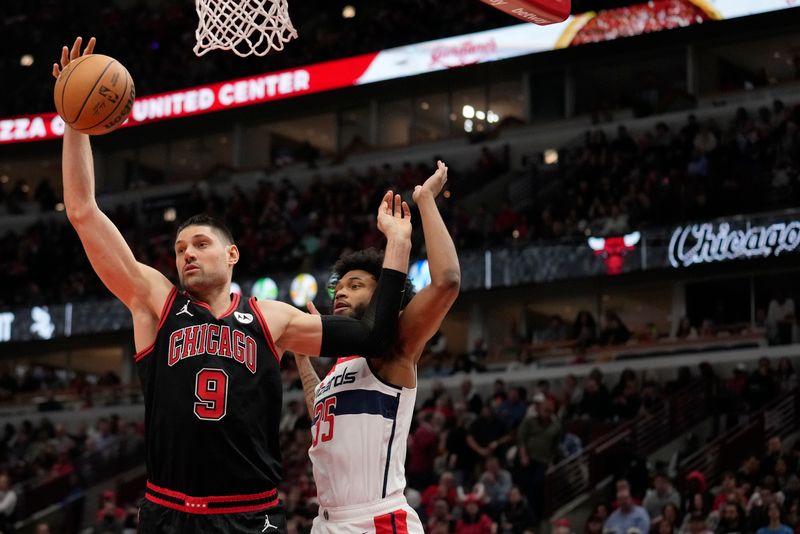 CHICAGO, ILLINOIS - MARCH 25: Nikola Vucevic #9 of the Chicago Bulls rebounds the ball against Marvin Bagley III #35 of the Washington Wizards during the first half at the United Center on March 25, 2024 in Chicago, Illinois. NOTE TO USER: User expressly acknowledges and agrees that, by downloading and or using this photograph, User is consenting to the terms and conditions of the Getty Images License Agreement. (Photo by Patrick McDermott/Getty Images)