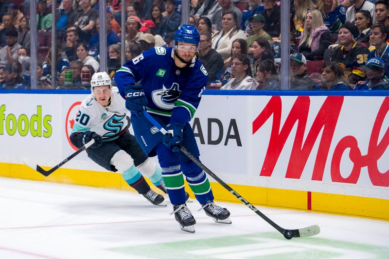 Sep 24, 2024; Vancouver, British Columbia, CAN; Vancouver Canucks defenseman Christian Wolanin (86) handles the puck against Seattle Kraken forward Eeli Tolvanen (20) during the second period at Rogers Arena. Mandatory Credit: Bob Frid-Imagn Images