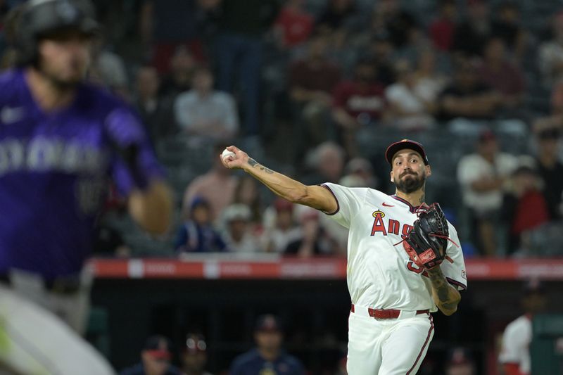 Aug 1, 2024; Anaheim, California, USA;  A throwing error by Los Angeles Angels relief pitcher Hans Crouse (52) off a bunt Colorado Rockies center fielder Sam Hilliard (16) allowed second baseman Aaron Schunk (30) to score the winning run in the tenth inning at Angel Stadium. Mandatory Credit: Jayne Kamin-Oncea-USA TODAY Sports