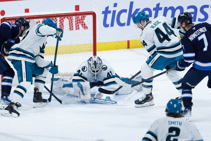 Feb 24, 2025; Winnipeg, Manitoba, CAN;  San Jose Sharks goalie Vitek Vanecek (41) smothers the puck as Winnipeg Jets forward Vladislav Namestnikov (7) and Winnipeg Jets forward Cole Perfetti (91) look for a rebound during the third period at Canada Life Centre. Mandatory Credit: Terrence Lee-Imagn Images