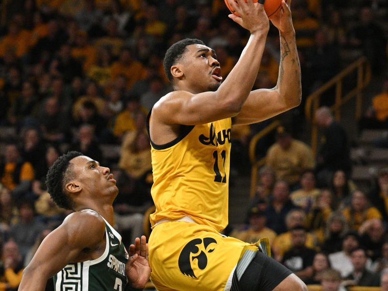 Feb 25, 2023; Iowa City, Iowa, USA; Iowa Hawkeyes guard Tony Perkins (11) goes to the basket as Michigan State Spartans guard Tyson Walker (2) looks on during the second half at Carver-Hawkeye Arena. Mandatory Credit: Jeffrey Becker-USA TODAY Sports