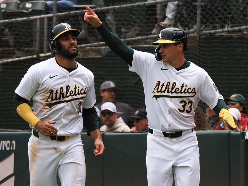 May 25, 2024; Oakland, California, USA; Oakland Athletics third baseman Abraham Toro (31) and center fielder JJ Bleday (33) celebrate after being batted in for two runs against the Houston Astros during the first inning at Oakland-Alameda County Coliseum. Mandatory Credit: Kelley L Cox-USA TODAY Sports