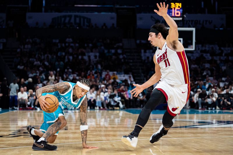 CHARLOTTE, NORTH CAROLINA - OCTOBER 26: Tre Mann #23 of the Charlotte Hornets dribbles the ball while guarded by Jaime Jaquez Jr. #11 of the Miami Heat in the first quarter during their game at Spectrum Center on October 26, 2024 in Charlotte, North Carolina. NOTE TO USER: User expressly acknowledges and agrees that, by downloading and or using this photograph, User is consenting to the terms and conditions of the Getty Images License Agreement. (Photo by Jacob Kupferman/Getty Images)