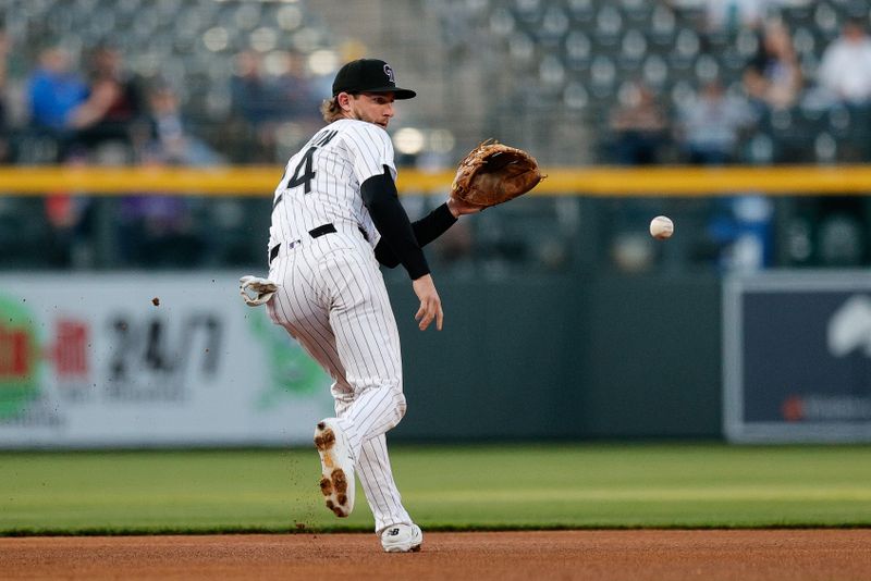 Apr 9, 2025; Denver, Colorado, USA; Colorado Rockies third baseman Ryan McMahon (24) fields the ball in the first inning against the Milwaukee Brewers at Coors Field. Mandatory Credit: Isaiah J. Downing-Imagn Images