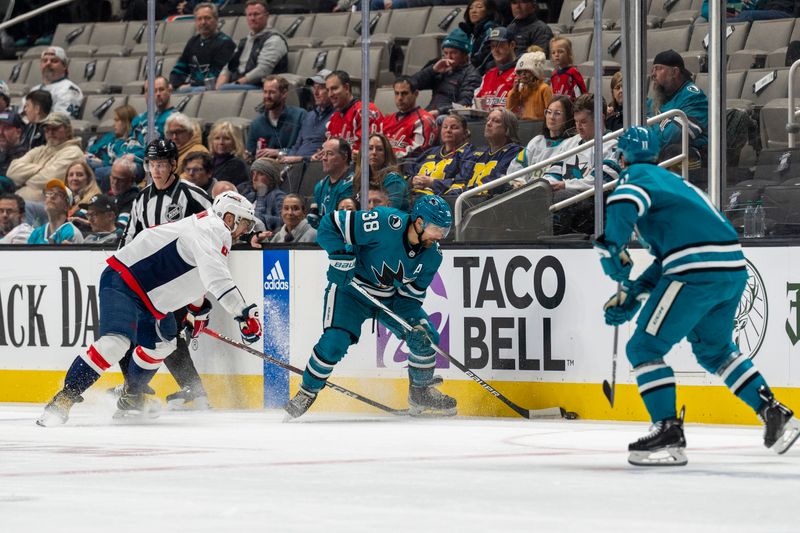 Nov 27, 2023; San Jose, California, USA; San Jose Sharks defenseman Mario Ferraro (38) controls the puck against Washington Capitals left wing Alex Ovechkin (8) on the boards during the first period at SAP Center at San Jose. Mandatory Credit: Neville E. Guard-USA TODAY Sports