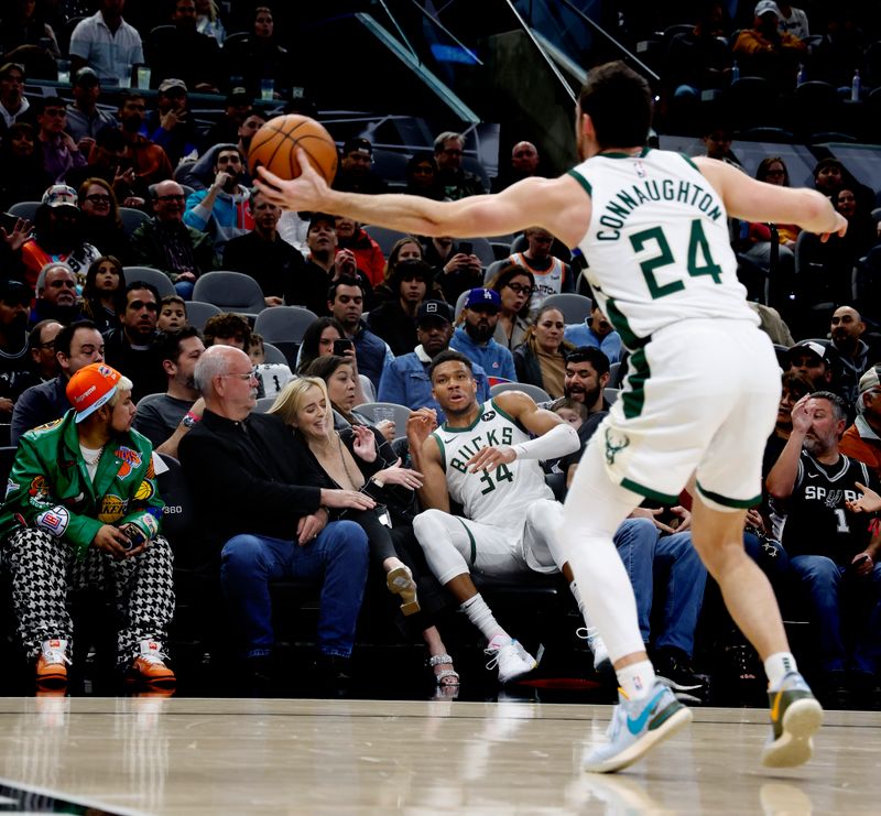 SAN ANTONIO, TX - JANUARY  04:  Giannis Antetokounmpo #34 of the Milwaukee Bucks lands in the seats after making a save against the San Antonio Spurs in the first half at Frost Bank Center on January  04, 2024 in San Antonio, Texas. NOTE TO USER: User expressly acknowledges and agrees that, by downloading and or using this photograph, User is consenting to terms and conditions of the Getty Images License Agreement. (Photo by Ronald Cortes/Getty Images)