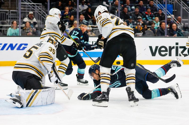 Feb 26, 2024; Seattle, Washington, USA; Seattle Kraken center Alex Wennberg (21) dives out of the way of a shot by a teammate against Boston Bruins goaltender Linus Ullmark (35) during the first period at Climate Pledge Arena. Mandatory Credit: Joe Nicholson-USA TODAY Sports