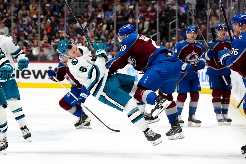 Dec 31, 2023; Denver, Colorado, USA; Colorado Avalanche center Nathan MacKinnon (29) hits San Jose Sharks defenseman Ty Emberson (6) in the second period at Ball Arena. Mandatory Credit: Ron Chenoy-USA TODAY Sports