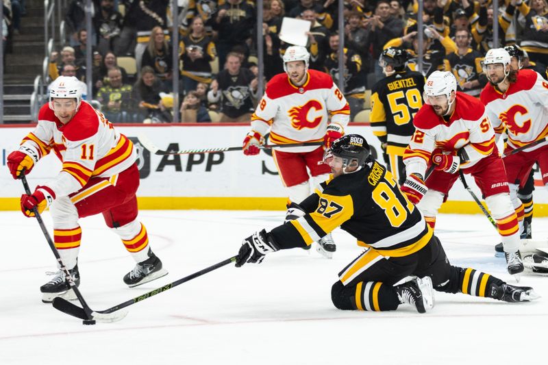 Oct 14, 2023; Pittsburgh, Pennsylvania, USA; Pittsburgh Penguins center Sidney Crosby (87) reaches to take the puck away from Calgary Flames center Mikael Backlund (11) during the first period at PPG Paints Arena. Mandatory Credit: Scott Galvin-USA TODAY Sports