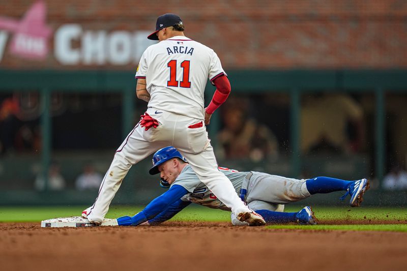 May 14, 2024; Cumberland, Georgia, USA; Atlanta Braves shortstop Orlando Arcia (11) gets a force out on Chicago Cubs center fielder Pete Crow-Armstrong (52) during the third inning at Truist Park. Mandatory Credit: Dale Zanine-USA TODAY Sports