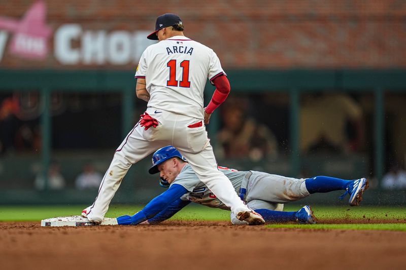 May 14, 2024; Cumberland, Georgia, USA; Atlanta Braves shortstop Orlando Arcia (11) gets a force out on Chicago Cubs center fielder Pete Crow-Armstrong (52) during the third inning at Truist Park. Mandatory Credit: Dale Zanine-USA TODAY Sports