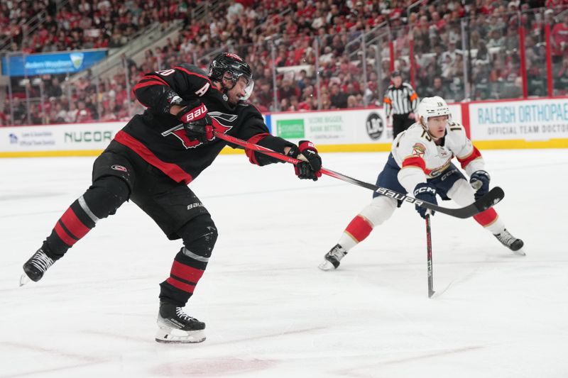 May 20, 2025; Raleigh, North Carolina, USA; Carolina Hurricanes forward Sebastian Aho (20) shoots the puckk as Florida Panthers forward Anton Lundell (15) defends during the first period in game one of the Eastern Conference Final of the 2025 Stanley Cup Playoffs at Lenovo Center. Mandatory Credit: James Guillory-Imagn Images