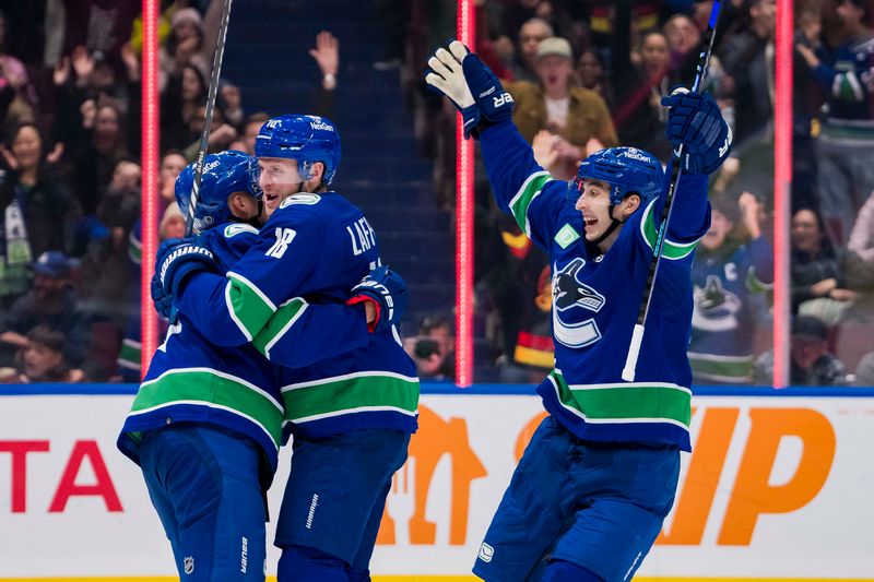 Dec 9, 2023; Vancouver, British Columbia, CAN; Vancouver Canucks forward Elias Pettersson (40) and forward Sam Lafferty (18) and forward Ilya Mikheyev (65) celebrate Pettersson   s goal against the Carolina Hurricanes in the third period at Rogers Arena. Vancouver won 4-3. Mandatory Credit: Bob Frid-USA TODAY Sports