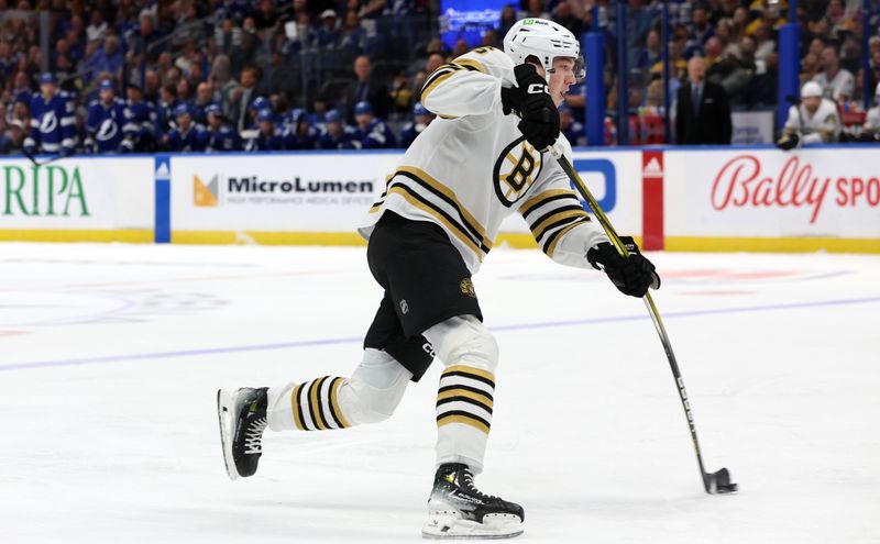 Nov 20, 2023; Tampa, Florida, USA; Boston Bruins defenseman Mason Lohrei (6) shoots against the Tampa Bay Lightning during the second period at Amalie Arena. Mandatory Credit: Kim Klement Neitzel-USA TODAY Sports