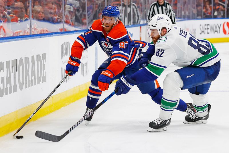 May 12, 2024; Edmonton, Alberta, CAN; Edmonton Oilers forward Connor McDavid (97) carries the puck around Vancouver Canucks defensemen Ian Cole (82) during the third period in game three of the second round of the 2024 Stanley Cup Playoffs at Rogers Place. Mandatory Credit: Perry Nelson-USA TODAY Sports