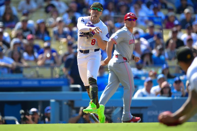 May 19, 2024; Los Angeles, California, USA; Los Angeles Dodgers third baseman Enrique Hernandez (8) throws to first for the out against Cincinnati Reds first base Jeimer Candelario (3) during the tenth inning at Dodger Stadium. Mandatory Credit: Gary A. Vasquez-USA TODAY Sports