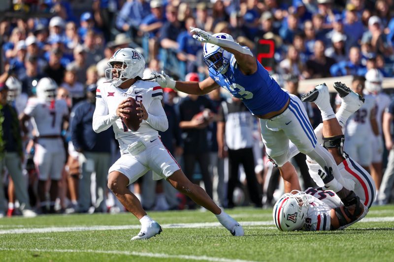 Oct 12, 2024; Provo, Utah, USA; Brigham Young Cougars defensive end Isaiah Bagnah (13) pressures Arizona Wildcats quarterback Noah Fifita (11) during the first quarter at LaVell Edwards Stadium. Mandatory Credit: Rob Gray-Imagn Images