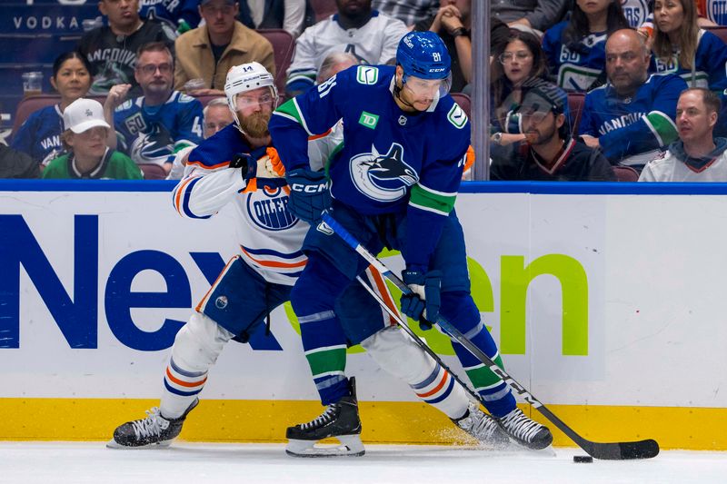 May 20, 2024; Vancouver, British Columbia, CAN; Edmonton Oilers defenseman Mattias Ekholm (14) battles with Vancouver Canucks forward Dakota Joshua (81) during the second period in game seven of the second round of the 2024 Stanley Cup Playoffs at Rogers Arena. Mandatory Credit: Bob Frid-USA TODAY Sports